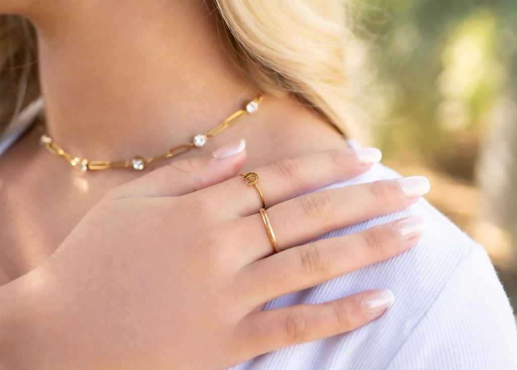 Collier Éclat doré porté avec une tenue claire