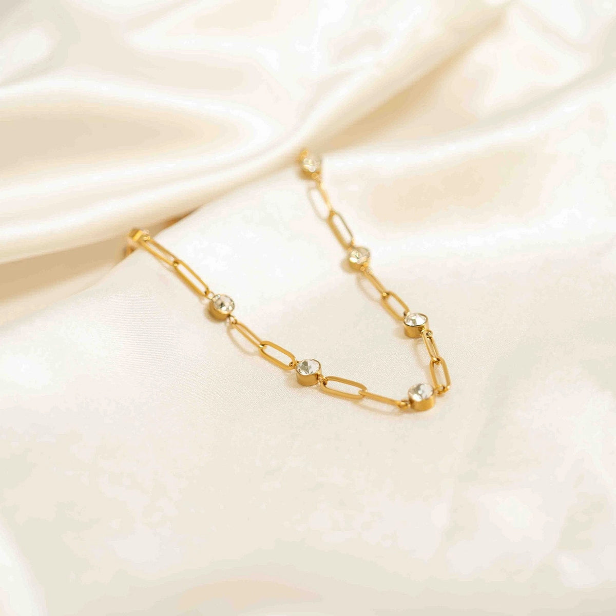 Détail du collier Éclat doré et de ses cristaux sur tissu clair