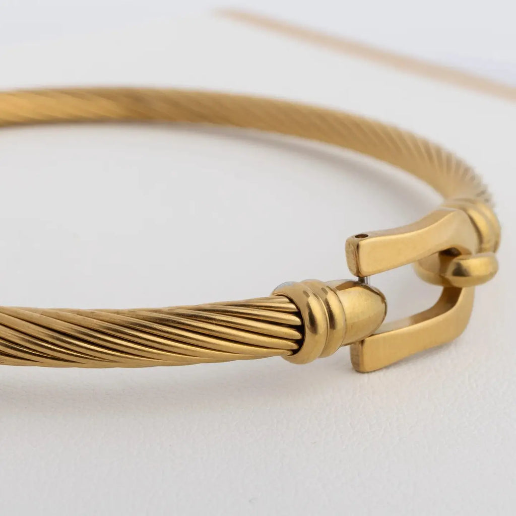 Détail du fermoir et de la texture torsadée du bracelet Aurum doré